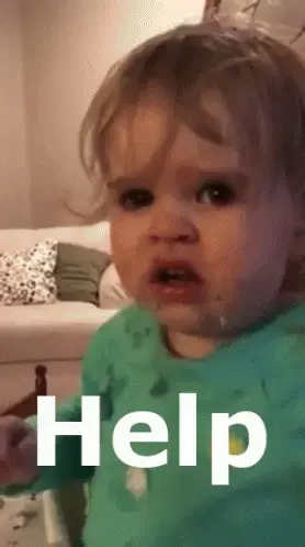 A Baby With A Green Shirt On Says Help