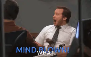A Man Sitting At A Desk With His Mouth Open And The Words Mind Blown What Behind Him