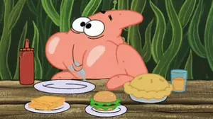 Patrick Star Is Sitting At A Table With Plates Of Food .