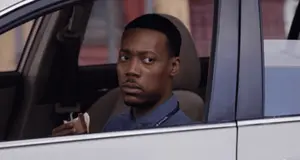 A Man Sitting In A Car With A Lanyard Around His Neck That Says Dispatcher On It