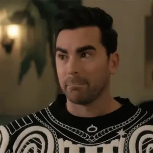 A Man With A Beard Is Wearing A Black And White Sweater And Making A Face .