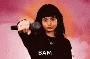 A Young Woman Is Holding A Microphone In Her Hand And Pointing At The Camera .