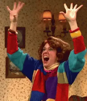 A Woman In A Colorful Sweater Has Her Arms In The Air