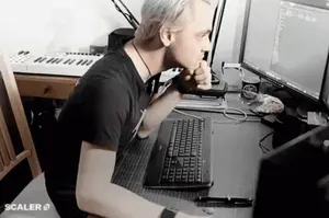 A Man Is Sitting At A Desk With A Keyboard And A Monitor With Scaler 5 Written On The Bottom