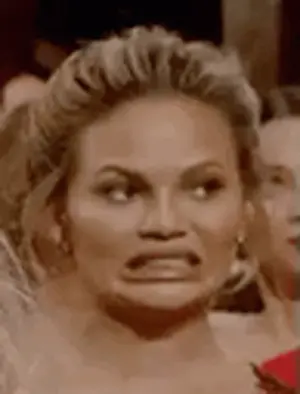 A Woman Is Making A Funny Face While Sitting In A Crowd Of People .