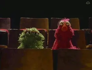 Two Sesame Street Characters Are Sitting In A Theater Watching A Show