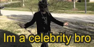 A Man In A Cowboy Hat Is Standing In The Grass With The Words " I 'M A Celebrity Bro " Above Him