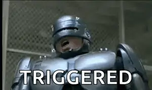 A Robot Is Standing In Front Of A Fence And Says `` Triggered '' .