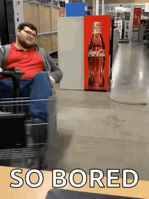 A Man Sits In A Cart In Front Of A Coca Cola Machine