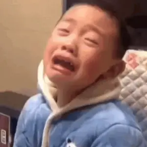 A Little Boy Is Crying With His Eyes Closed While Wearing A Blue Jacket .