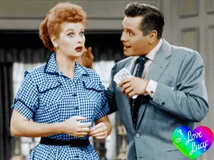 A Man And A Woman Are Standing Next To Each Other With A Heart That Says " I Love Lucy " On It