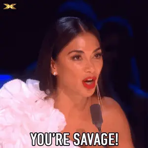 A Woman Speaking Into A Microphone With The Words You 'Re Savage Below Her