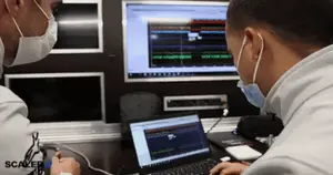 A Man Wearing A Mask Looks At A Laptop Screen With The Word Scaler On The Bottom