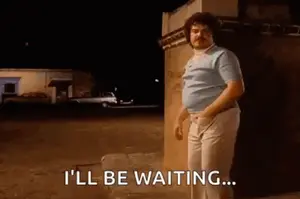 A Man With A Mustache Is Standing In Front Of A Building At Night And Says `` I 'Ll Be Waiting '' .