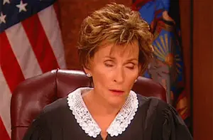 A Female Judge Sitting In Front Of An American Flag
