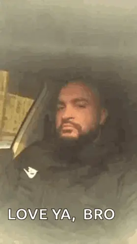 A Man With A Beard Is Sitting In A Car With His Eyes Closed And The Words `` Love Ya , Bro '' .
