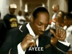 Snoop Dogg Is Wearing A Suit And Tie And Is Holding A Ring In His Hand .