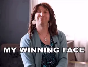 A Woman In A Blue Sweater Says " My Winning Face " In Black Letters
