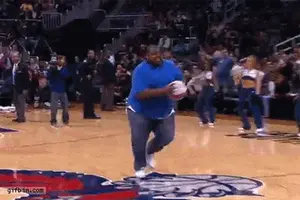 A Man In A Blue Shirt Is Running On A Basketball Court Holding A Basketball .