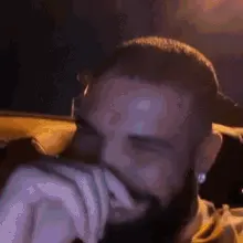 A Close Up Of A Man With A Beard Covering His Face With His Hands .