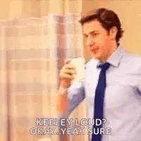 A Man In A Suit And Tie Is Drinking A Cup Of Coffee And Talking To Someone .