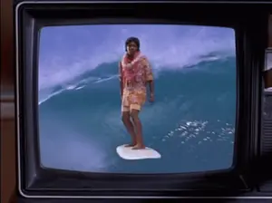 A Man Standing On A Surfboard In The Ocean