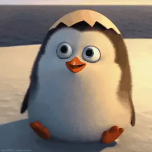 A Cartoon Penguin Is Sitting On A Beach With Its Head In An Egg Shell