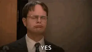 Dwight Schrute From The Office Is Wearing Glasses And A Suit And Tie .