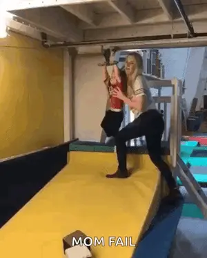 A Woman Is Holding A Child On A Yellow Mat With The Words Mom Fail Written On It