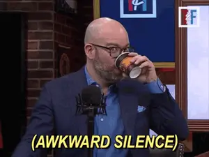 A Man In A Suit Drinking From A Cup With The Words Awkward Silence Behind Him