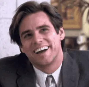 A Man In A Suit And Tie Is Smiling With His Mouth Open