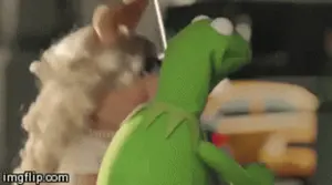 Kermit The Frog And Miss Piggy Are Kissing Each Other In A Muppet Show .