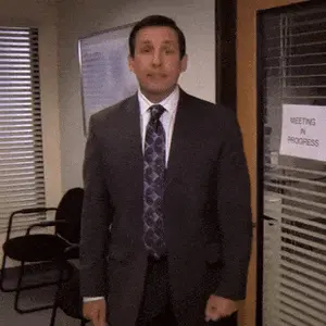 A Man In A Suit And Tie Is Standing In Front Of A Door That Says Meeting In Progress