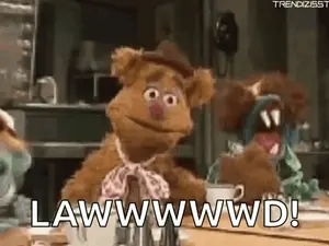 Fozzie Bear From The Muppet Show Is Sitting At A Table With A Cup Of Coffee And A Bow Tie .