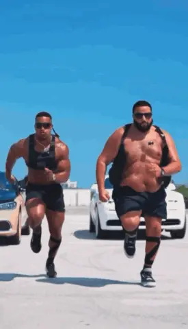 Two Men Are Running In A Parking Lot And One Has A Sticker On His Chest That Says ' A ' On It