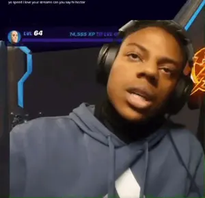 A Man Wearing Headphones With A Screen Behind Him That Says Yo Speed I Love Your Streams Can You Say Hi Hector