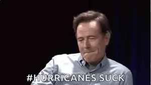 A Man Is Making A Funny Face And Saying `` Hurricanes Suck '' With His Hand .