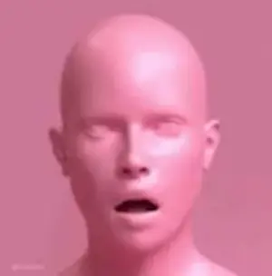 A Pink Statue Of A Bald Man With His Mouth Open And His Eyes Closed .