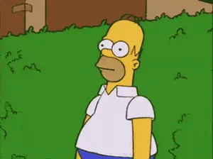 A Cartoon Of Homer Simpson Standing In A Grassy Area