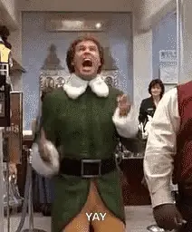 A Man In A Green Elf Costume Is Dancing In A Room With His Mouth Open .