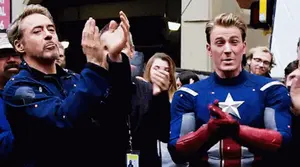 Iron Man And Captain America Are Clapping In Front Of A Crowd Of People