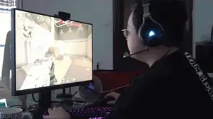 A Man Wearing Headphones Playing A Video Game On A Dell Monitor