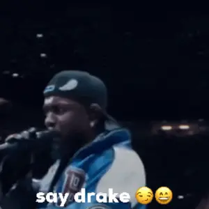 A Man Is Holding A Microphone With The Words Say Drake Below Him