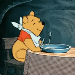 Winnie The Pooh Sitting At A Table With A Bowl Of Food And A Spoon