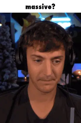 A Man Wearing Headphones Is Making A Funny Face With The Caption Massive