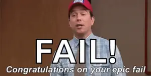 A Man Wearing A Red Hat Is Standing In Front Of A Sign That Says Fail !