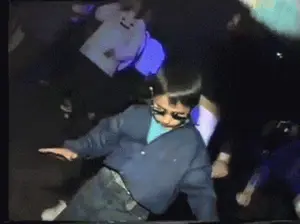 A Boy Wearing Sunglasses And A Blue Shirt Is Dancing