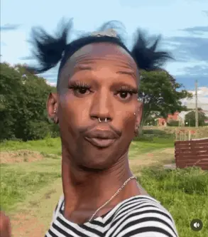 A Man Wearing A Striped Shirt And A Nose Ring Is Making A Funny Face .