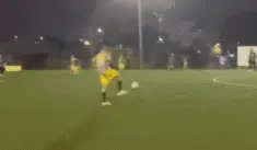 A Soccer Player Is Laying On The Ground While Another Player Runs Towards Him .