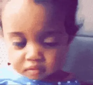 A Close Up Of A Baby 'S Face With A Sad Look On His Face